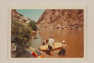 Bill Mooz inflates the small unit which was to convoy the air mattresses on Lake Mead to get them to Pierce Ferry. Looking upriver about Mile 234 1/2