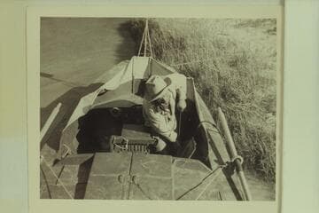 Dock Marston pumps the bilge of the "Esmeralda II"; foot of Tanner Trail