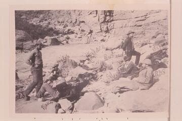 "A Noonday Rest in Marble Canon. Showing Well the Head of a Fall." Left to right: Travers, Hislop, Kane, Gibson, Ballard, Edwards, Twining (standing), Stanton, McDonald, Brown