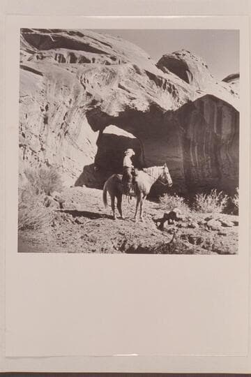 Nancy Daly sits her horse in front of the natural bridge in a side canyon of Navajo Canyon, Arizona. The bridge may have been a discovery on 1954, Sep. 26 when this photo was taken Masland suggests naming the bridge White-hat Bridge