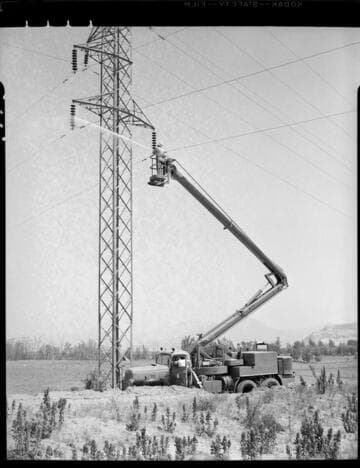 Washing insulators on double circuit tower with high pressure water nozzle from raised bucket