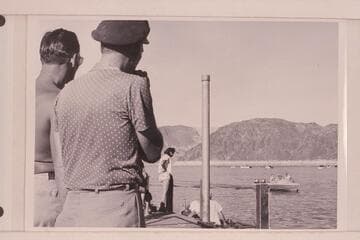 Danny Daniels and Jimmy Jordan watch the "RATTLESNAKE" in a trial run in the boat harbor at Boulder City. The boat is powered with two 25HP Evinrude motors. Bill Belknap is at the controls