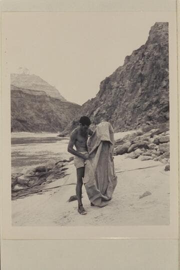 Garth Marston examines the rubber raft lost in Glen Canyon by the Scout troop and found at Mile 219 in the Grand Canyon by the Nevills party. At Diamond Creek